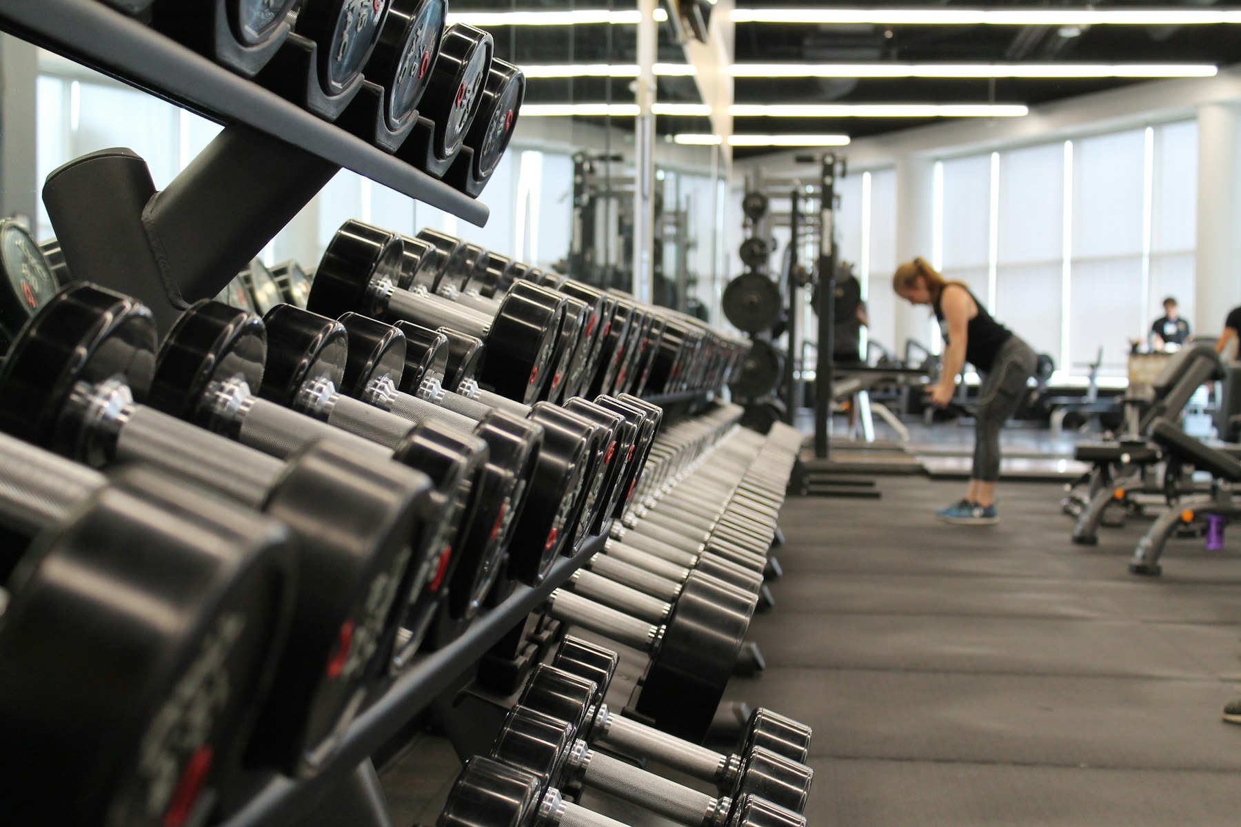 Strength floor with a dumbbell rack and a member training